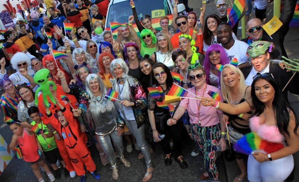 A group of staff in bright costumes for the Pride parade